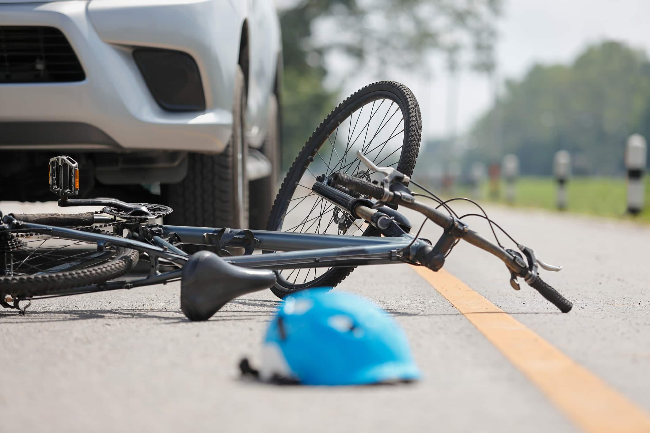 A bicycle lays in the road between a black sedan and ambulance after a bicycle accident in Lodi, NJ.